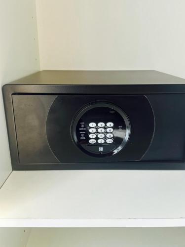 a black microwave oven sitting on top of a shelf at Leonidas House in Parga