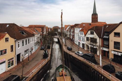 a city street with buildings and a canal at Zur Mühle - Hotel am Fleth in Buxtehude