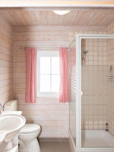a bathroom with a toilet and a tub and a sink at Moerenhof Blockhütte Xanten in Xanten