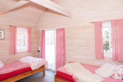 a bedroom with two beds and two windows at Moerenhof Blockhütte Xanten in Xanten