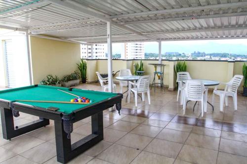 a pool table in a room with tables and chairs at Hotel Flamboyant Taubate in Taubaté