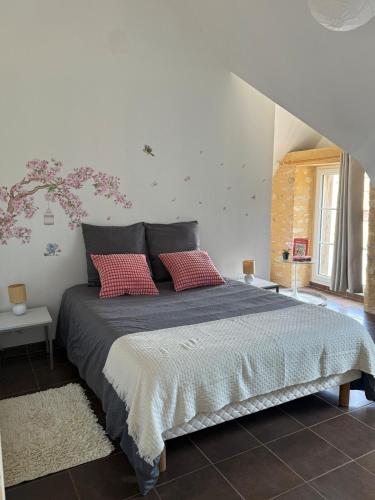 une chambre avec un grand lit avec des oreillers rouges dans l'établissement Gîtes Fleur des Pommiers, près des plages du débarquement, à Juaye-Mondaye