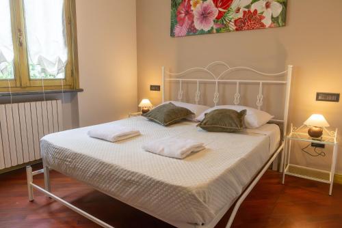 una camera da letto con un letto bianco con due asciugamani sopra di Villa Sun Kiss a Volta Mantovana