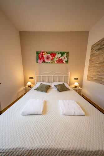 a bedroom with a white bed with two pillows at Villa Sun Kiss in Volta Mantovana