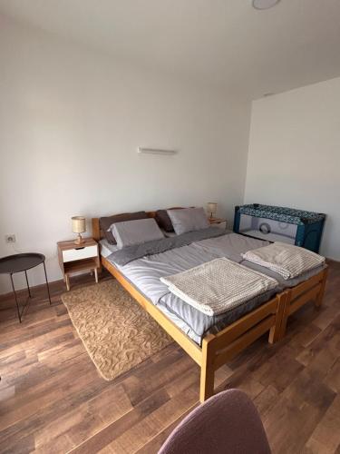 a large bed in a room with a wooden floor at Apartmani Dana in Vranje