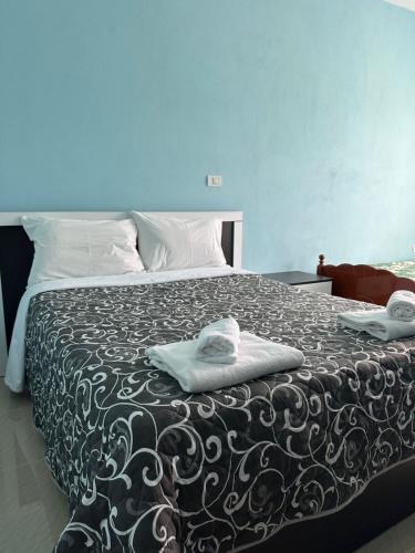 a bedroom with a bed with towels on it at Hotel Restaurant Aleksander in Korçë
