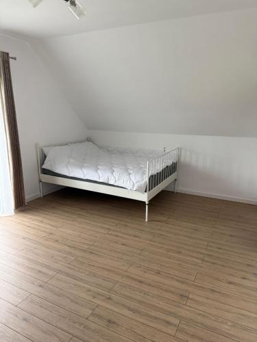 a white bed in a room with a wooden floor at Cabana cu Livada in Mintiu Gherlii
