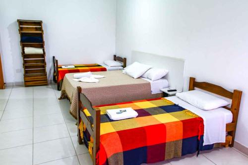 a room with two beds and a staircase in it at Hotel Flamboyant Taubate in Taubaté
