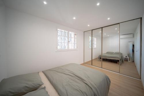 une chambre avec un lit et un grand miroir dans l'établissement hameau des pins, à Saint-Raphaël