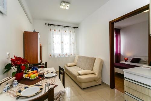 a kitchen and living room with a table and a chair at Apartmani Cvelic in Malinska