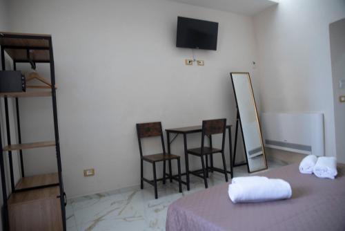 a room with a bed with a table and chairs at La Dolce Vita rooms & suite in Agrigento