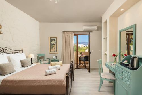a bedroom with a bed and a desk and a window at Mistral Hotel - For Solo Travelers in Maleme