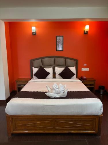 a bedroom with a bed with a white flower on it at Hotel KASTURI PALACE & RESTAURANT DARJEELING in Darjeeling