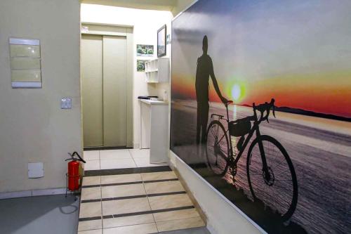 a wall mural of a man on a bike in a kitchen at Hotel Flamboyant Taubate in Taubaté