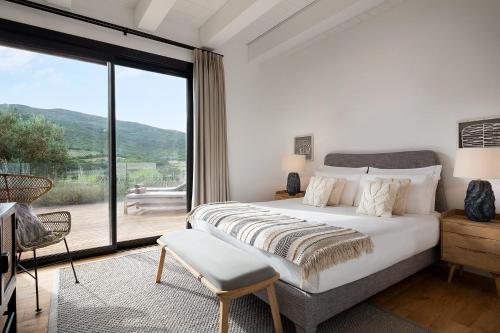a bedroom with a large bed and a large window at Argentario Golf Villas in Porto Ercole
