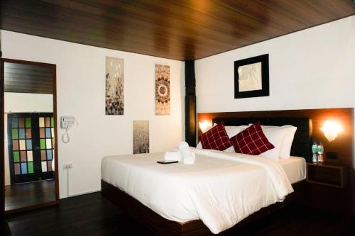 a bedroom with a large white bed with red pillows at Ilocos Urban Wave Resort in Laoag