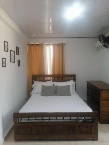 a bedroom with a large bed with white sheets and pillows at Tu espacio en zona colonial in Santo Domingo