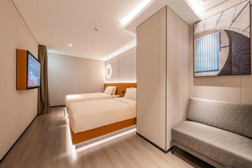 a hotel room with a bed and a couch at Atour Hotel Beijing Tiananmen Wangfujing Pedestrian in Beijing