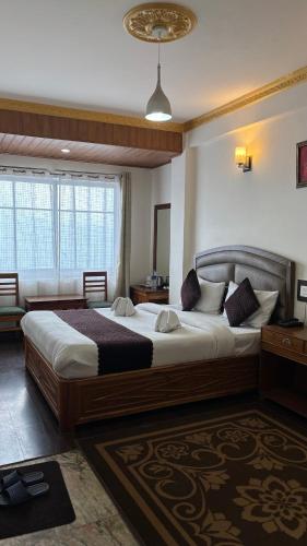 a bedroom with two beds in a room at Hotel KASTURI PALACE & RESTAURANT DARJEELING in Darjeeling