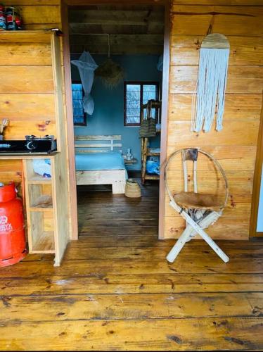 a room with a bed and a chair in a cabin at michamvi mangrove cabin in Michamvi