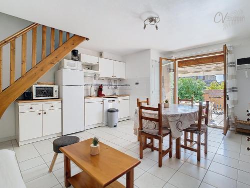 une cuisine et une salle à manger avec une table et des chaises dans l'établissement Maison Rayon du Soleil dans résidence privée avec piscine, à Vias