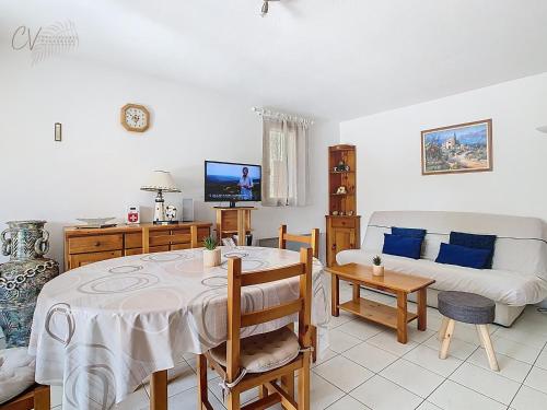 un salon avec une table et un canapé dans l'établissement Maison Rayon du Soleil dans résidence privée avec piscine, à Vias