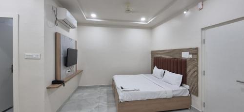 a bedroom with a bed and a television in it at Hotel Vaarahi Chanda Nagar, Near Hitech City in Hyderabad