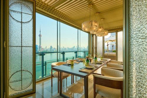 上海上海外滩悦榕庄 - 顶楼露台Tales餐厅酒吧纵览浦江美景的一间享有城市美景的用餐室