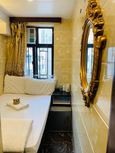 a small room with a bed and a mirror at Maharaja Guest House Block C in Hong Kong