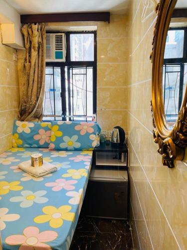 a small room with a bed with a mirror at Maharaja Guest House Block C in Hong Kong