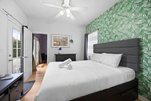 a bedroom with a large bed with a green accent wall at Cozy Backhouse Stay – Sleeps 2 Beverly Hills Adj in Los Angeles