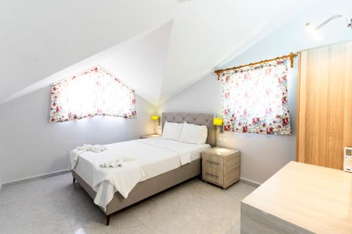 a bedroom with a bed and two windows at Legend Of Dalyan Hotel in Dalyan