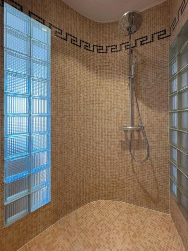 une salle de bain avec une douche avec une porte vitrée dans l'établissement Charmante maison de village avec petite piscine privée, au Cannet