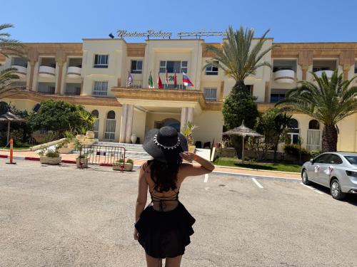 a woman standing in front of a building at Marina Palace in Hammamet