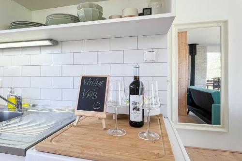a bottle of wine and two wine glasses on a cutting board at Chatka in Roztiezi in Roztěž