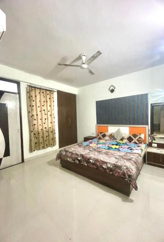 ジャイプールにあるZenRoofs- Homely 2BHK Apartmentのベッドと天井扇風機のある寝室
