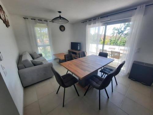 un salon avec une table et des chaises en bois dans l'établissement Appartement neuf et climatisé, 6 personnes, à 150m de la plage, à Vias