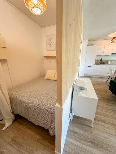 une petite chambre avec un lit et un bureau dans l'établissement Studio wifi, parking privatif privé, clim, proche plage et polygone riviera, à Cagnes-sur-Mer