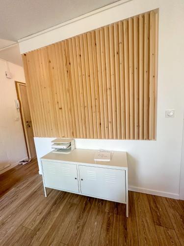 un bureau blanc dans une pièce avec un mur en bois dans l'établissement Studio wifi, parking privatif privé, clim, proche plage et polygone riviera, à Cagnes-sur-Mer