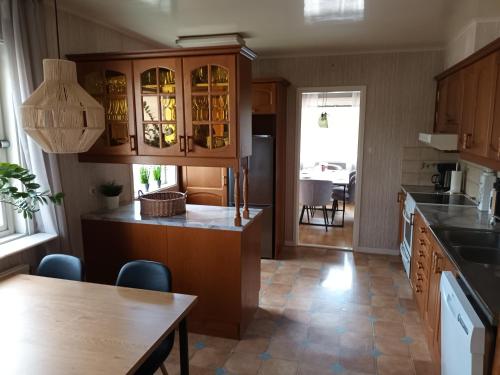 a kitchen with wooden cabinets and a dining table at Willa Sysslebäck in Sysslebäck