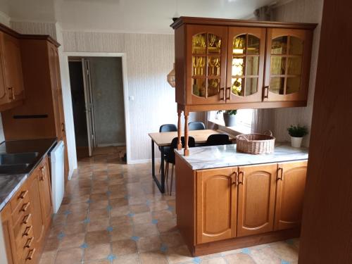 a kitchen with wooden cabinets and a table at Willa Sysslebäck in Sysslebäck