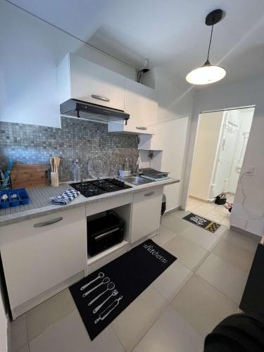 une cuisine avec un évier et une cuisinière four supérieur dans l'établissement Appartement f3 vue mer, à Fréjus