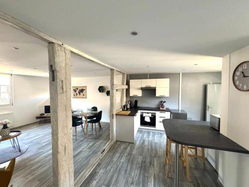 a kitchen and living room with a table and a clock at Au coeur de Kaysersberg-Le Cocon de Jeanne in Kaysersberg