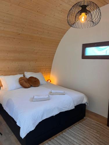 a bedroom with a bed with two pillows on it at Luxurious Tiny House with HotTub in Rijsenhout