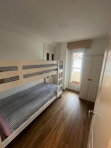 a bedroom with two bunk beds and a wooden floor at Duplex con Terraza en Mogro in Mogro