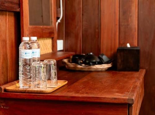 two bottles of water sitting on top of a wooden table at Rak Chiang Mai Guesthouse in Chiang Mai