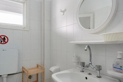 a white bathroom with a sink and a mirror at Ilias Studios Sevasti Kalymnos in Panormos Kalymnos