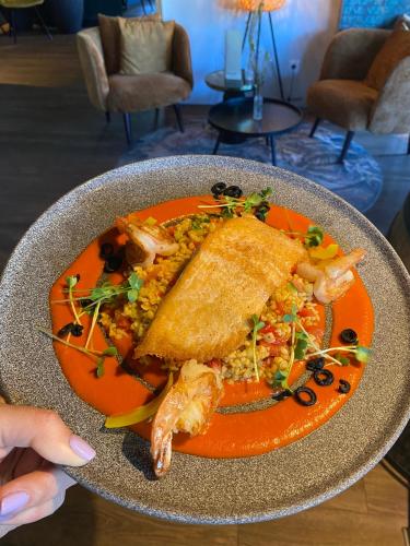 a plate of food with a sandwich and shrimp on it at Dahoam by Sarina - Village Appartements in Zell am See