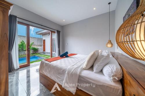 a bedroom with a bed and a large window at Traditional Villa Astina Cemagi in Cemagi