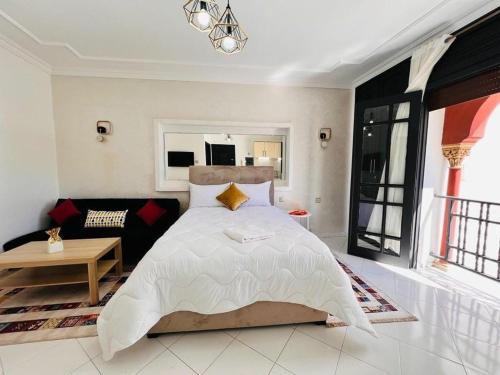 a bedroom with a large bed and a couch at Studio confort Centre Rabat Hassan in Rabat